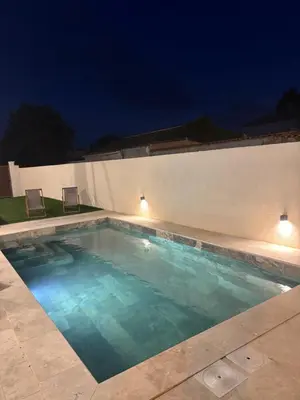 a swimming pool at night with lights on the wall at Villa Zen in Entraigues-sur-la-Sorgue