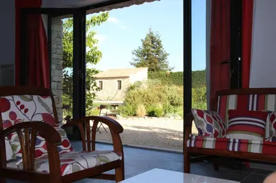 a room with two chairs and a sliding glass door at La cigale bleue in Gordes