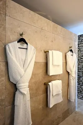 a bathroom with white towels hanging on a wall at La Suite Gordes in Gordes