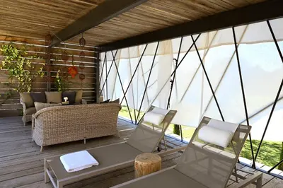 a screened in porch with two chairs and a couch at La Suite Gordes in Gordes