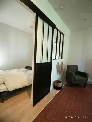 a bedroom with a door leading to a bed and a chair at Cosy et lumineux - hyper centre - wifi in Aix-en-Provence