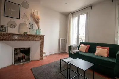 a living room with a green couch and a fireplace at Cosy et lumineux - hyper centre - wifi in Aix-en-Provence