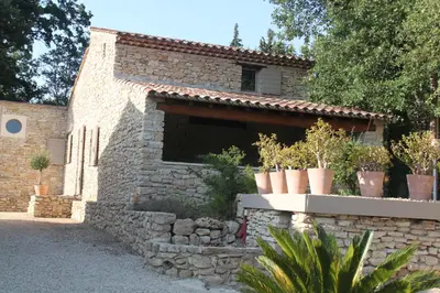 a stone building with potted plants on it at Le Gîte du Hameau Fleur de Pierres in Gordes