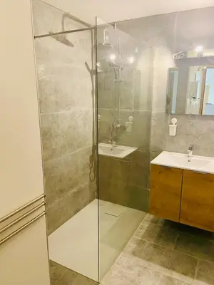 a bathroom with a glass shower and a sink at La maison d'Antoine à Robion in Robion en Luberon
