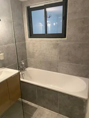 a bathroom with a white tub and a window at La maison d'Antoine à Robion in Robion en Luberon
