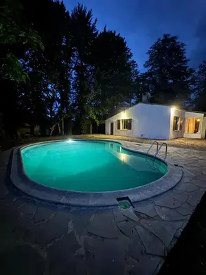a swimming pool at night with a house in the background at La maison vauclusienne in Carpentras
