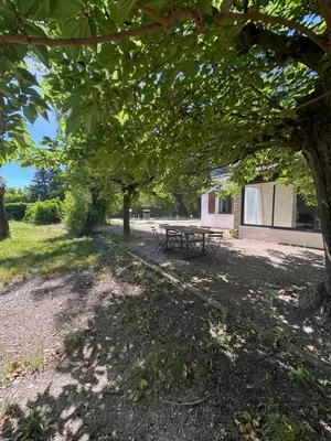 a picnic table under a tree in a park at La maison vauclusienne in Carpentras