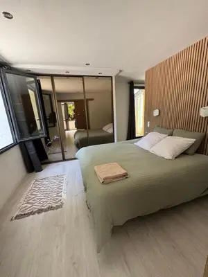 a bedroom with a large bed and a large window at La maison vauclusienne in Carpentras