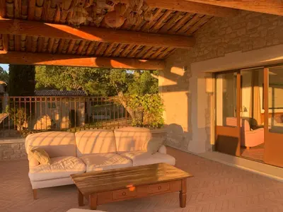 a couch on a patio with a coffee table at Les Noyers in Montjustin