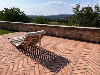 a wooden bench sitting on a brick patio at Les Noyers in Montjustin