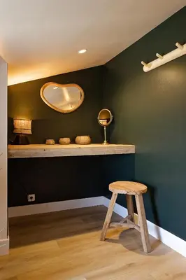 a stool in a room with a green wall at Maison Paulette in Eygalières
