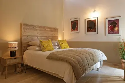 a bedroom with a bed with a wooden headboard at Maison Paulette in Eygalières