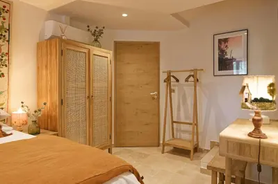 a bedroom with a bed and a wooden door at Maison Paulette in Eygalières
