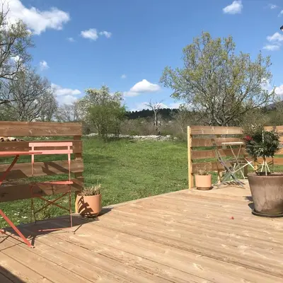 a wooden deck with a bench and a table at Le Mas de Loume in Sault-de-Vaucluse