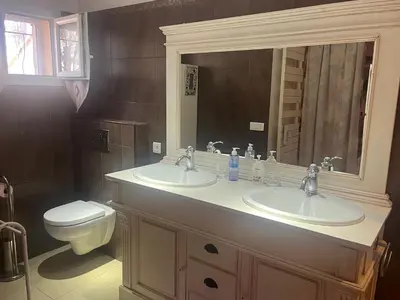 a bathroom with two sinks and a toilet at La Louvière Plaine d'Eygalières in Orgon
