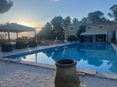 a large swimming pool in front of a house at La Louvière Plaine d'Eygalières in Orgon