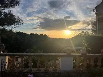 a sunset over a fence with the sun in the background at La Louvière Plaine d'Eygalières in Orgon