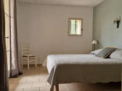 a bedroom with a bed and a window at Villa Trempadou in Gordes