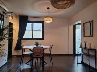 a dining room with a table and chairs and a window at Appartement cosy avec exterieur au coeur de la Provence in Monteux