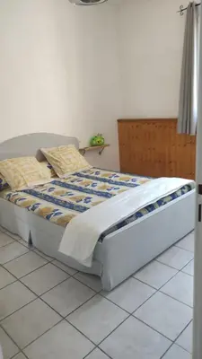 a bed sitting on a tiled floor in a bedroom at L'Appart in Cheval-Blanc
