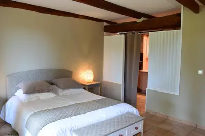 a bedroom with a bed with a lamp on a table at La Chambre des Amis au Moulin des GYPSES, Ventoux in Mormoiron