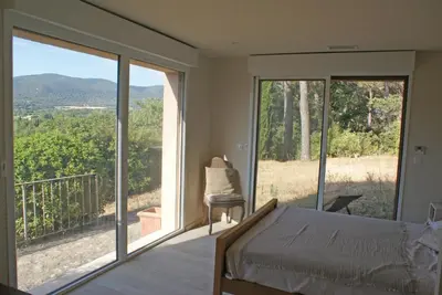 a bedroom with a bed and a balcony with a view at L'Irisciabella in Lourmarin