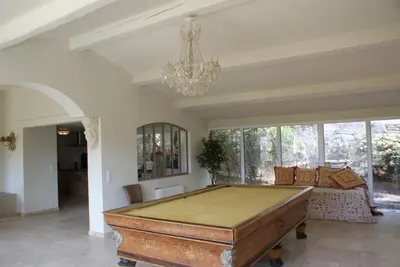 a pool table in a living room with a chandelier at L'Irisciabella in Lourmarin