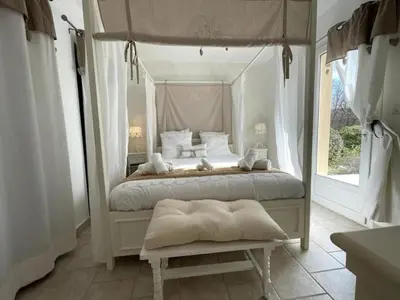 a bedroom with a canopy bed and a window at Le petit paradis au cœur du Luberon in Saint-Saturnin-les-Apt