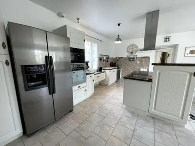 a large kitchen with a stainless steel refrigerator at Le petit paradis au cœur du Luberon in Saint-Saturnin-les-Apt