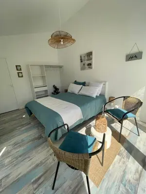 a bedroom with a bed and a chair at A l'ombre des oliviers in LʼIsle-sur-la-Sorgue