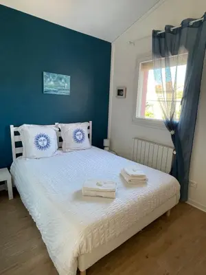 a bedroom with a bed with two towels on it at A l'ombre des oliviers in LʼIsle-sur-la-Sorgue