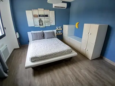 a bedroom with a bed and a blue wall at Villa moderne avec piscine in Monteux