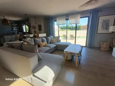 a living room with a couch and a table at Villa moderne avec piscine in Monteux