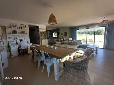 a living room with a wooden table and chairs at Villa moderne avec piscine in Monteux