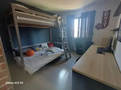 a bedroom with a bunk bed and a desk with a computer at Villa moderne avec piscine in Monteux