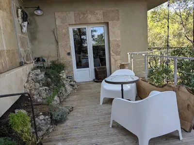 a patio with a table and chairs and a door at Charme, vue et piscine naturelle in Vedène