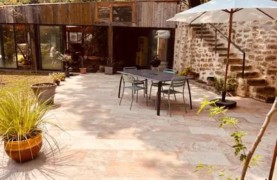 a patio with a table and chairs and an umbrella at Évasion charme et jacuzzi en pleine nature in Grans