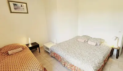a bedroom with a bed and a side table with a lamp at Maison provençale au milieu des champs in Robion en Luberon
