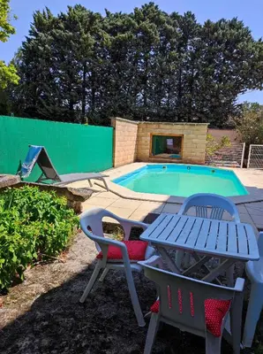 a patio with a table and chairs next to a swimming pool at Maison provençale au milieu des champs in Robion en Luberon