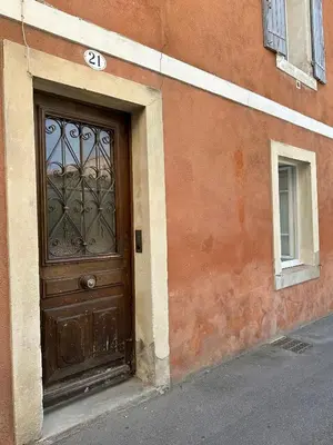 a building with a wooden door with a gate at Studio centre ville la Toscane in LʼIsle-sur-la-Sorgue