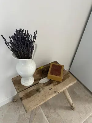 a vase and a book sitting on a wooden table with a vase at Studio centre ville la Toscane in LʼIsle-sur-la-Sorgue