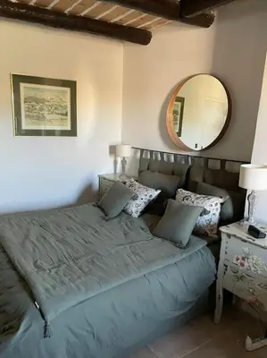 a bedroom with a large bed with a mirror at Village home in Ménerbes in Ménerbes