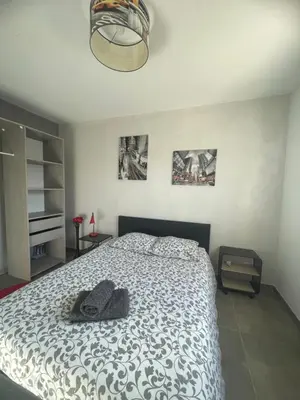 a bedroom with a bed with a black and white comforter at Chaleureuse maison in Cavaillon