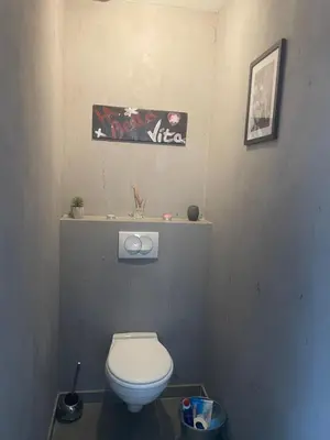 a bathroom with a toilet and a sign on the wall at Chaleureuse maison in Cavaillon
