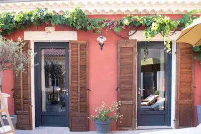 a red building with wooden doors and windows at La Maison Clémenceau in Salon-de-Provence