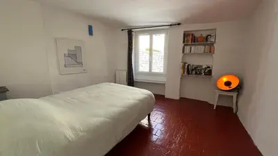 a bedroom with a white bed and a window at Charmante petite maison à Murs in Murs