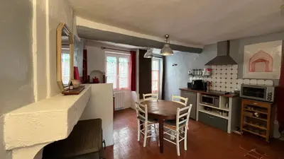 a kitchen and dining room with a table and chairs at Charmante petite maison à Murs in Murs
