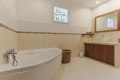 a white bathroom with a tub and a sink at Source de Vie in Noves