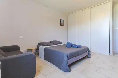 a bedroom with two beds and a chair in it at Source de Vie in Noves