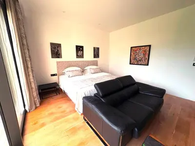 a bedroom with a bed and a leather couch at Belvédère Sainte Victoire in Saint-Marc-Jaumegarde